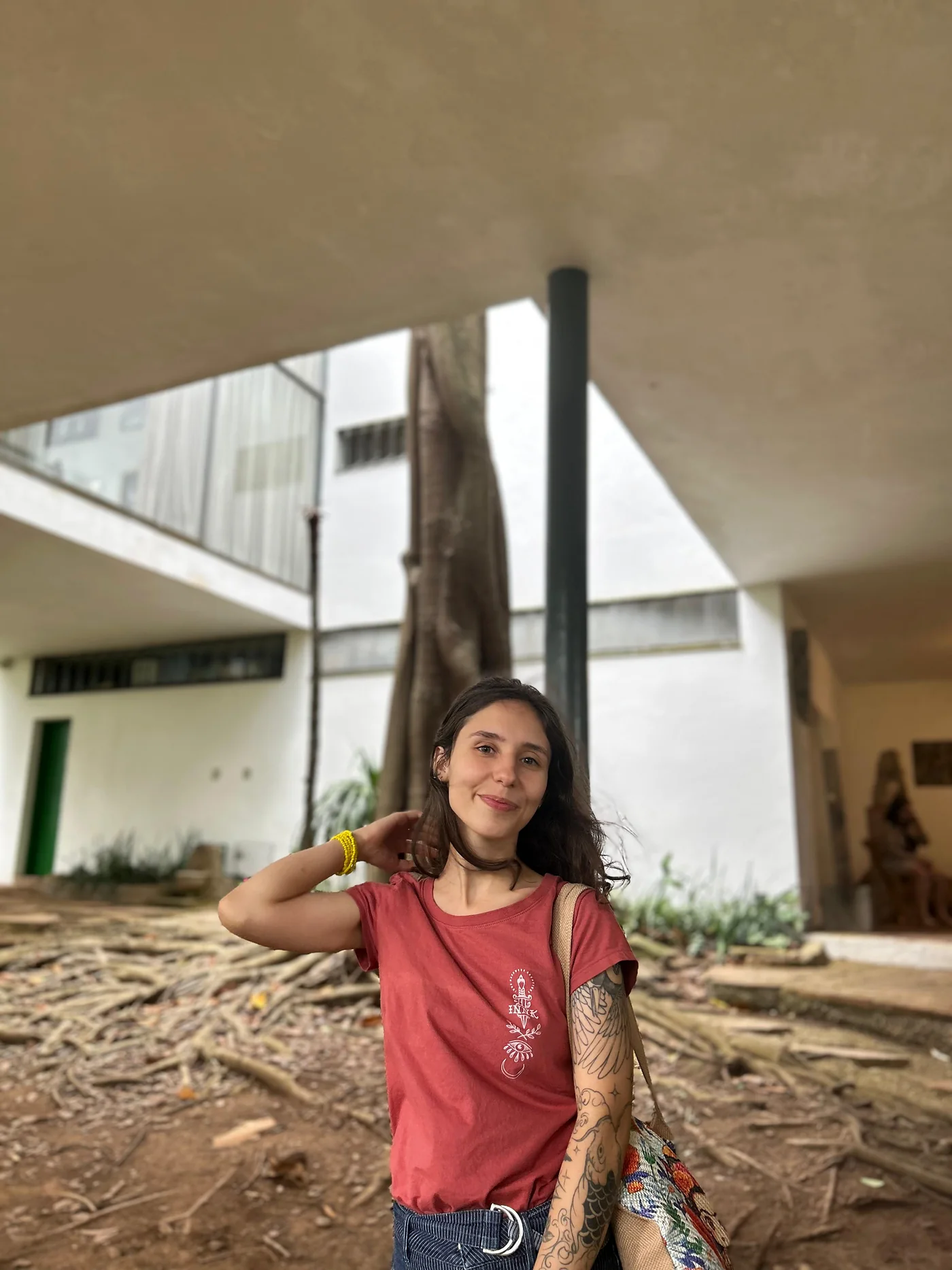 Karen sob a laje de uma casa modernista, com a mão no cabelo.