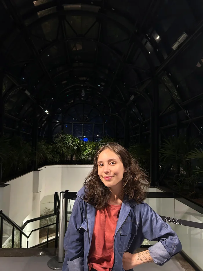 Karen à noite, de jaqueta azul, numa escadaria.