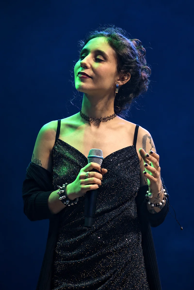 Karen no palco, com o microfone na mão.